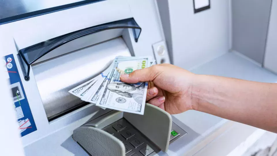 Person receiving money from ATM machine