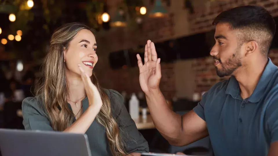 Man and woman in restaurant high fiving