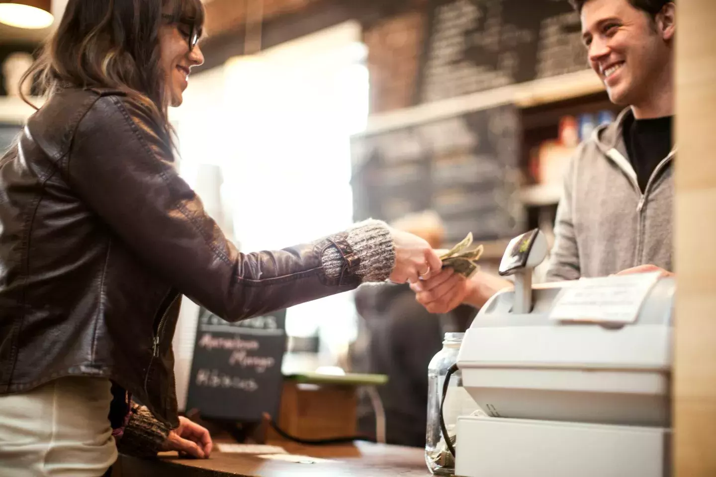 Women checking out at counter with cash